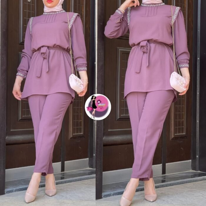 Model wearing dusty lilac Turkish two-piece set with jeweled collar, shoulder, and cuff embellishments – outdoor view. Elegant dusty lilac Turkish two-piece outfit with belted tunic and slim trousers – modest fashion style.